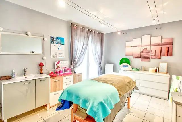 Une autre cabine : table de soin au drap turquoise, tableaux de ponton au soleil couchant